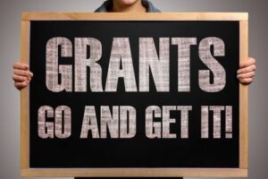 Person holding sign: GRANTS GO AND GET IT!