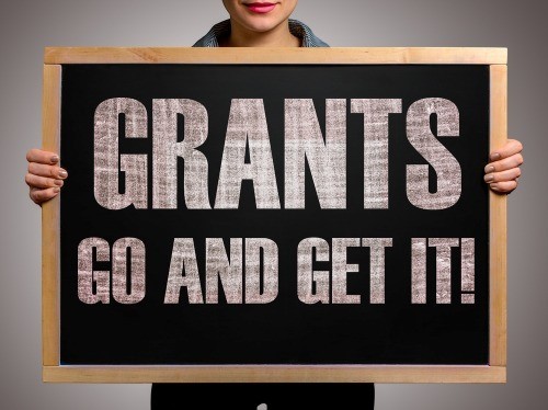 Person holding sign: GRANTS GO AND GET IT!