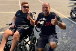 Michael O’Brien with wheelchair-bound 12-year-old boy, each with a thumbs-up pose.